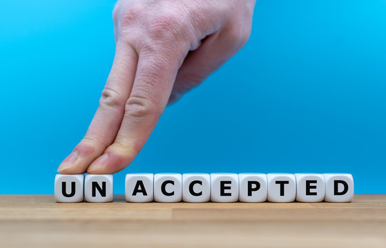 Dice form the word "UNACCEPTED" while two fingers push the letters "UN" away in order to change the word to "ACCEPTED".