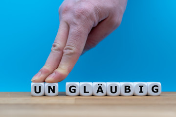 Zwei Finger schieben die Würfel mit den Buchstaben U und N zur Seite und verändern das aus...