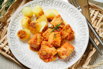 Meat stew with baked potatoes on white plate