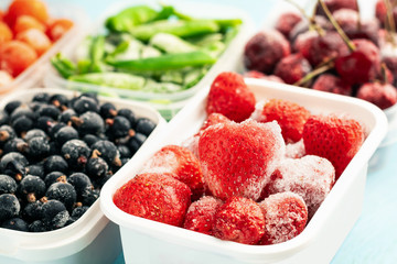 Frozen strawberries and other berries in plastic containers