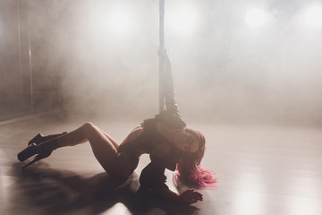 beautiful pole dancer in leather jacket on pylon.