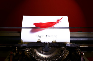 Vintage typewriter with bird feather. Light fiction genre concept