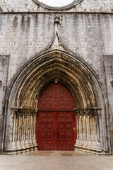 Fototapeta na wymiar Lisbon, Portugal external day view of Carmo Convent. Main portal entrance leading access to the nave ruins of The Convent of Our Lady of Mount Carmel, Convento da Ordem do Carmo.