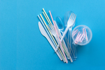 White single-use plastic and plastic drink straws on a blue background. Say no to single use...