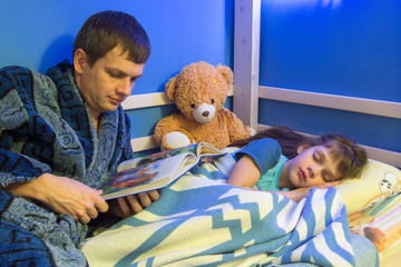 Dad reads book to daughter at night
