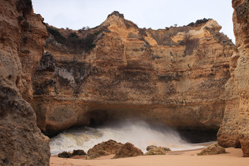 Hidden beach Praia da Ponta Pequena/Small Point Beach in Albufeira, Algarve, Portugal. Only known to locals. Waves coming in through a small opening in the cliff. 