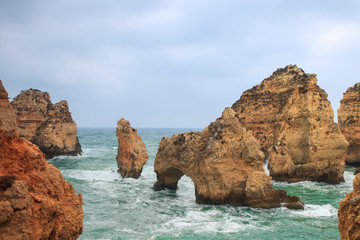 Fototapeta na wymiar Stone formations in the ocean at Ponta De Piedade tourist destination in Algarve, Portugal. 