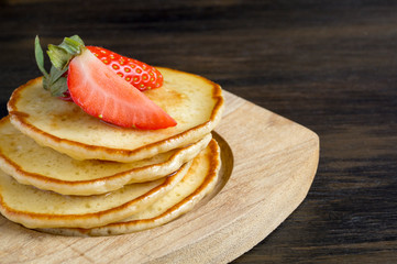 American pancakes with berries on a brown background.