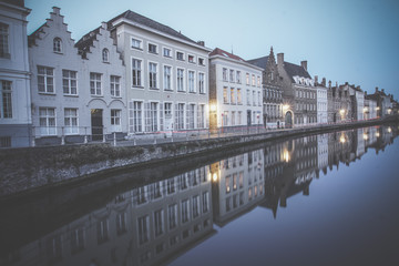 Reflection of houses in canal at night in Bruges, Belgium