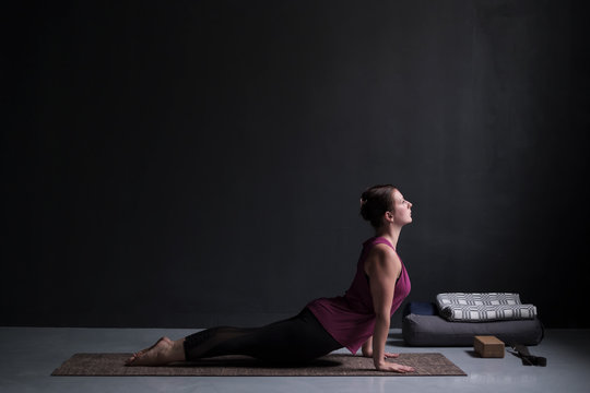 Woman practicing yoga, doing urdhva mukha svanasana, upward facing dog pose