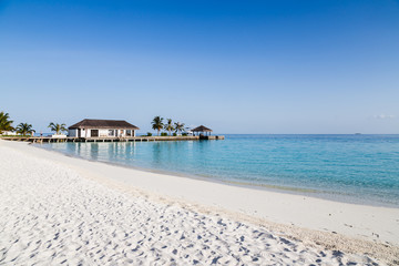 Water villas on the clear blue beach in the Maldives