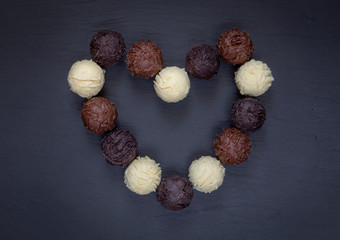 Chocolate truffles heart shape on black