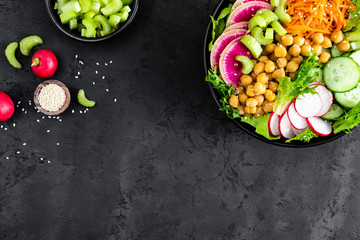 Salad Buddha bowl with fresh cucumber, celery, watermelon radish, raw carrot, lettuce, radish and chickpea for lunch. Healthy vegetarian food. Vegan vegetable dish. Top view