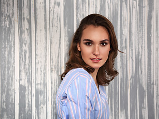 Fototapeta premium Beautiful sexy woman and looking serious in casual blue shirt and short curly hair. Closeup