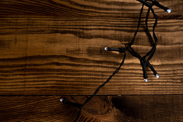 Christmas lights on the wooden background