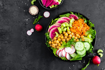 Fototapeta na wymiar Salad Buddha bowl with fresh cucumber, celery, watermelon radish, raw carrot, lettuce, radish and chickpea for lunch. Healthy vegetarian food. Vegan vegetable dish. Top view