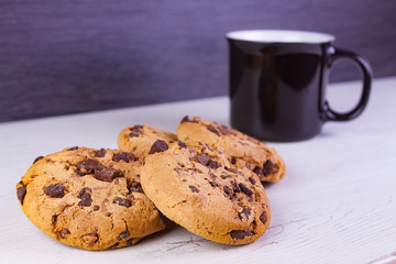 GALLETAS CON VIRUTAS DE CHOCOLATE Y TAZA NEGRA DE CAFÉ