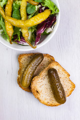TOSTADAS DE PAN CON PEPINILLOS Y BOL CON ENSALADA VERDE Y GUINDILLAS PICANTES EN VINAGRE