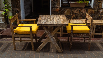 Wooden Table And Chairs With Bright Yellow Pillows