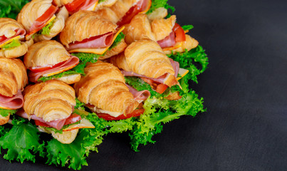 Croissant with sausage cheese and herbs on dark background