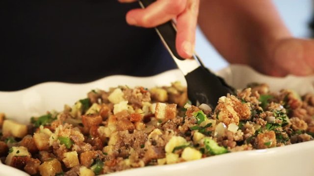 Person mixes sausage stuffing