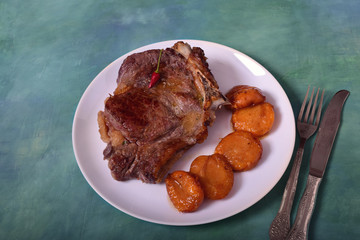 Beef steak with grilled apricots on a plate.