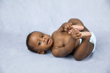 Sitting Up Adorable African American Baby Boy on a Grey Background