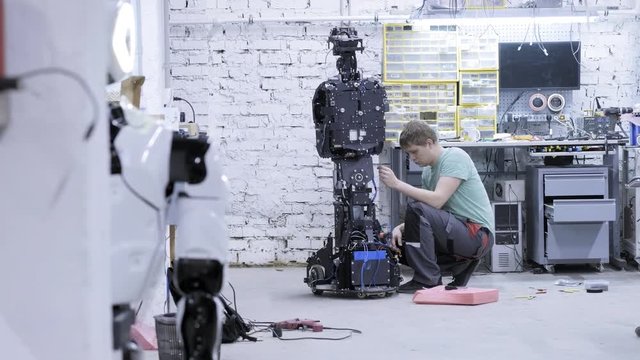 Factory for the production of robots, modern robotic developments. Engineer creates the insistent robot.