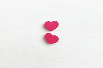The concept of Valentine's day. Valentine's day background. Two pink hearts isolated on white wooden background. Copy space. Place for your text.