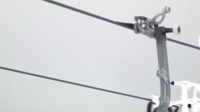 Closeup of an icy ski lift riding on a track.