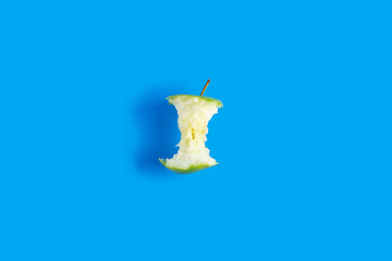 green Apple on blue background. Apple bitten