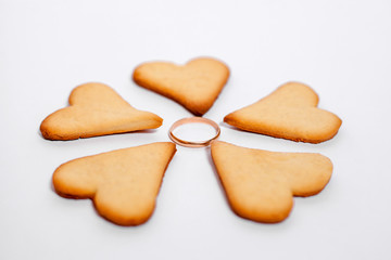 Hearts in the form of a flower with a wedding ring on a white background. Original marriage proposal. Flower from the heart.