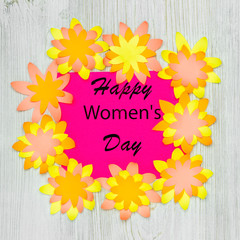 Wishing Happy Womens Day in paper flowers frame on wooden background. Flat lay