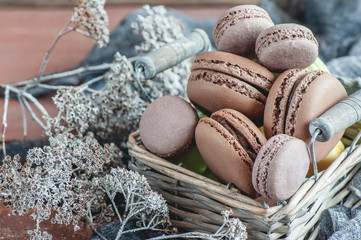 Delicate almond meringue macaroons in a wicker basket on the table. Close-up