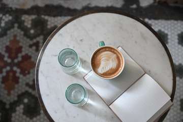 Coffee cup rests on open notebook