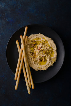 Hummus and breadsticks in a bowl
