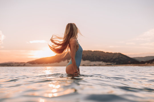 Girl with a gorgeous figure on the sea during sunset.Sexy girl on a wild beach.The girl in the water
