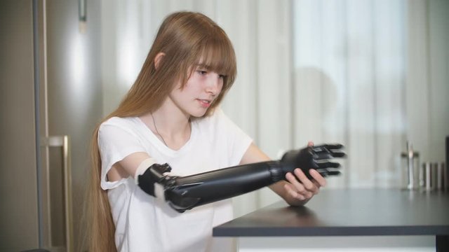 Disabled girl checking her metal prosthetic arm