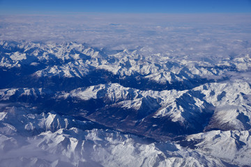 Fototapeta premium Aerial view of the rugged snow covered mountains of the Alps at the junction of Italy, France and Switzerland 