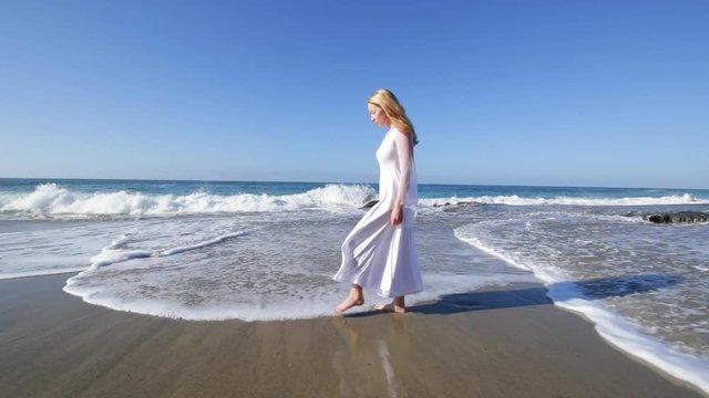 Woman in a white dress on the ocean coast