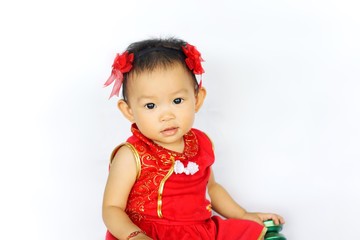 Chinese New Year festival concept, a Chinese 's baby girl in the red clothes. She holding a pocket money gift in her hand. On white background.