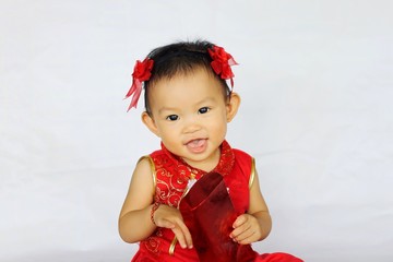 Chinese New Year festival concept, a Chinese 's baby girl in the red clothes. She holding a pocket money gift in her hand. On white background.