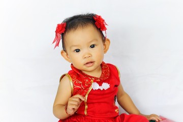 Chinese New Year festival concept, a Chinese 's baby girl in the red clothes. She holding a pocket money gift in her hand. On white background.
