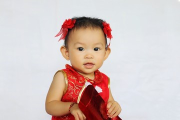 Chinese New Year festival concept, a Chinese 's baby girl in the red clothes. She holding a pocket money gift in her hand. On white background.