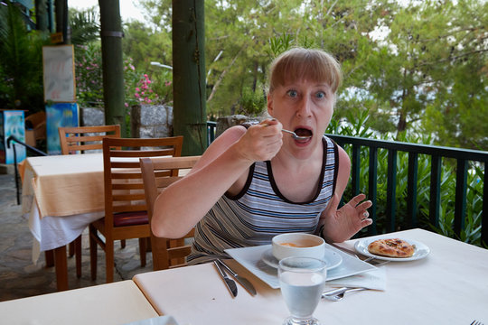 Middle-aged woman at a table in a restaurant on the street