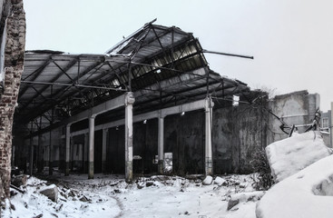 Ruined by war or other disaster industrial building in foggy winter 