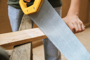 Man carries out carpentry carpenters work chopping wood board sawdust dust dangerous hand house learn sawdust steel work workshop occupation craftsman craft lumber timber. Close up view 