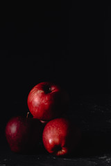Fototapeta na wymiar Red apples and slices of apples. Dark. Baton background. Photo in low key. Place fot text, copy paste space
