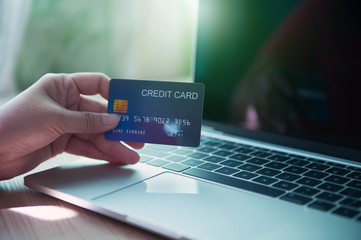 Business and financial concepts. Asian businesses hold credit cards for online purchases via mobile phones, laptops and pay with online banking via credit cards - images.