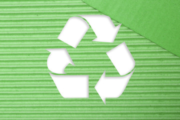 Symbol of recycling on green corrugated cardboard background